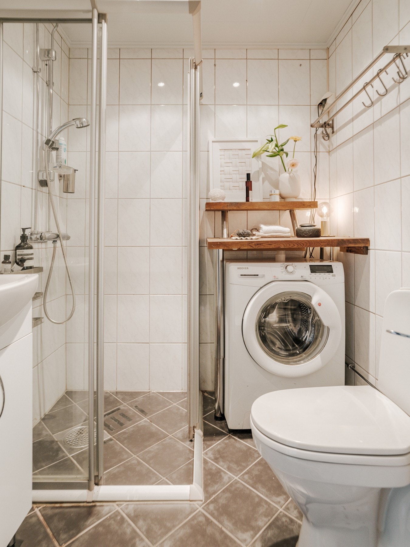 Pent baderom med varme i gulvstøp og og fliser på både gulv og vegg, Dusjhjørne på flis, opplegg til vaskemaskin og stående WC. Galleribilde