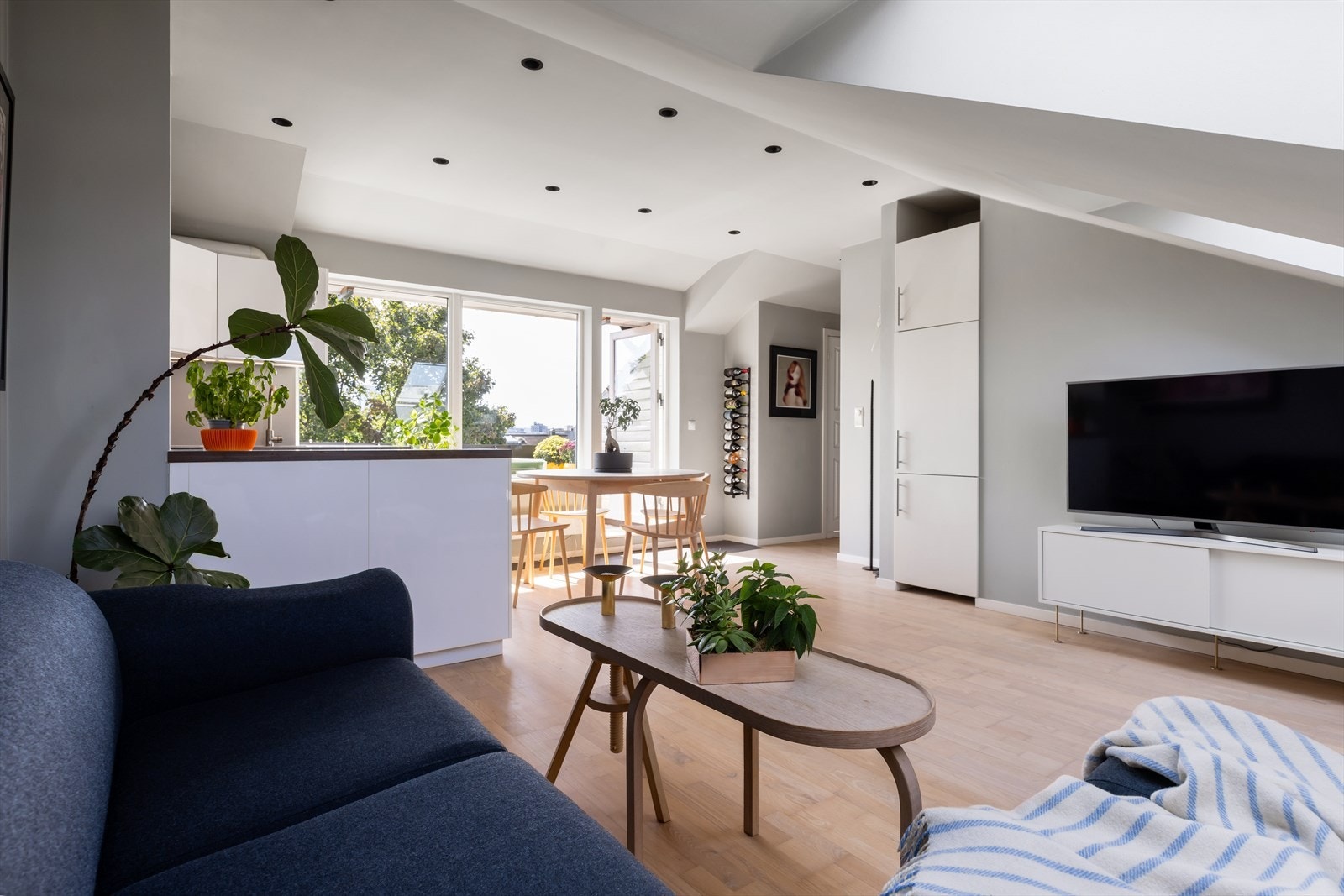 Den åpne stue-/kjøkkenløsningen bidrar til et sosialt oppholdsrom, med store vindusflater ut mot balkongen som fungerer som en forlengelse av rommet hele året. Galleribilde