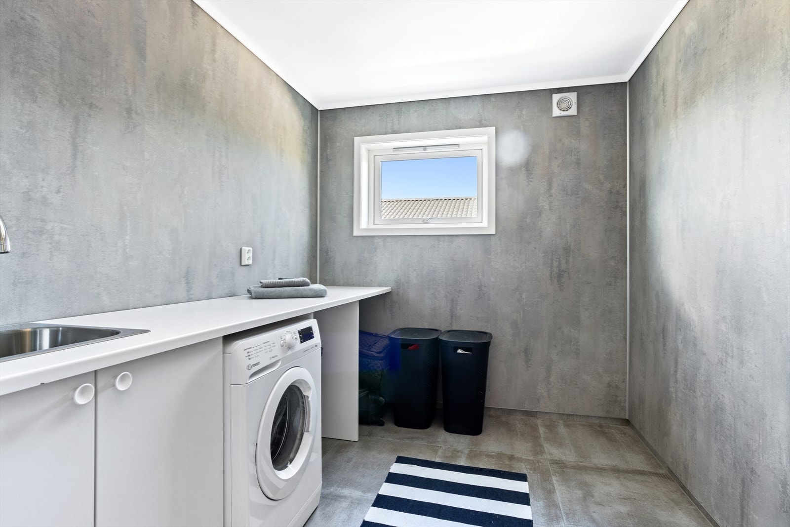 Hjemmet byr på et praktisk vaskerom - også her er det flislagt gulv med varmekabler. Galleribilde