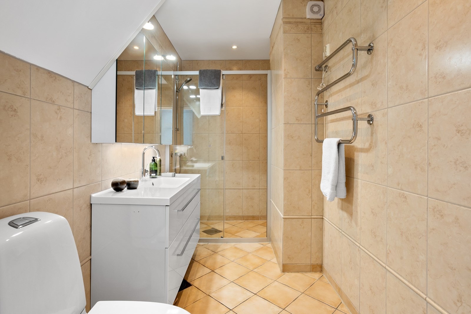 Det er "selvsagt" varmekabler under gulvflisene, og integrerte downlights i taket sørger for god belysning. Galleribilde