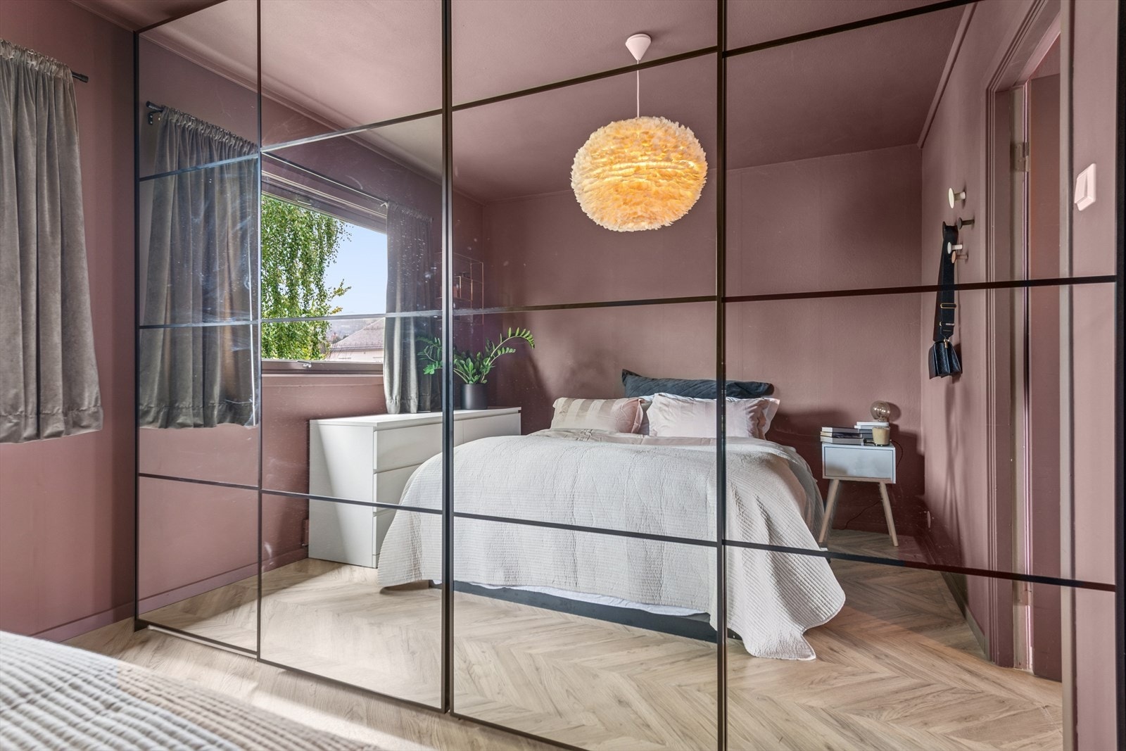 Innredet med en lekker skyvedørsgarderobe fra 2024, med speil og sorte profiler. Galleribilde