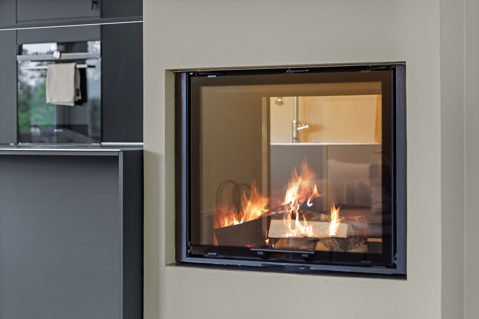 Lekker peis med to sider som gir varme, lys og lun atmosfære til både stue og spisestue Galleribilde