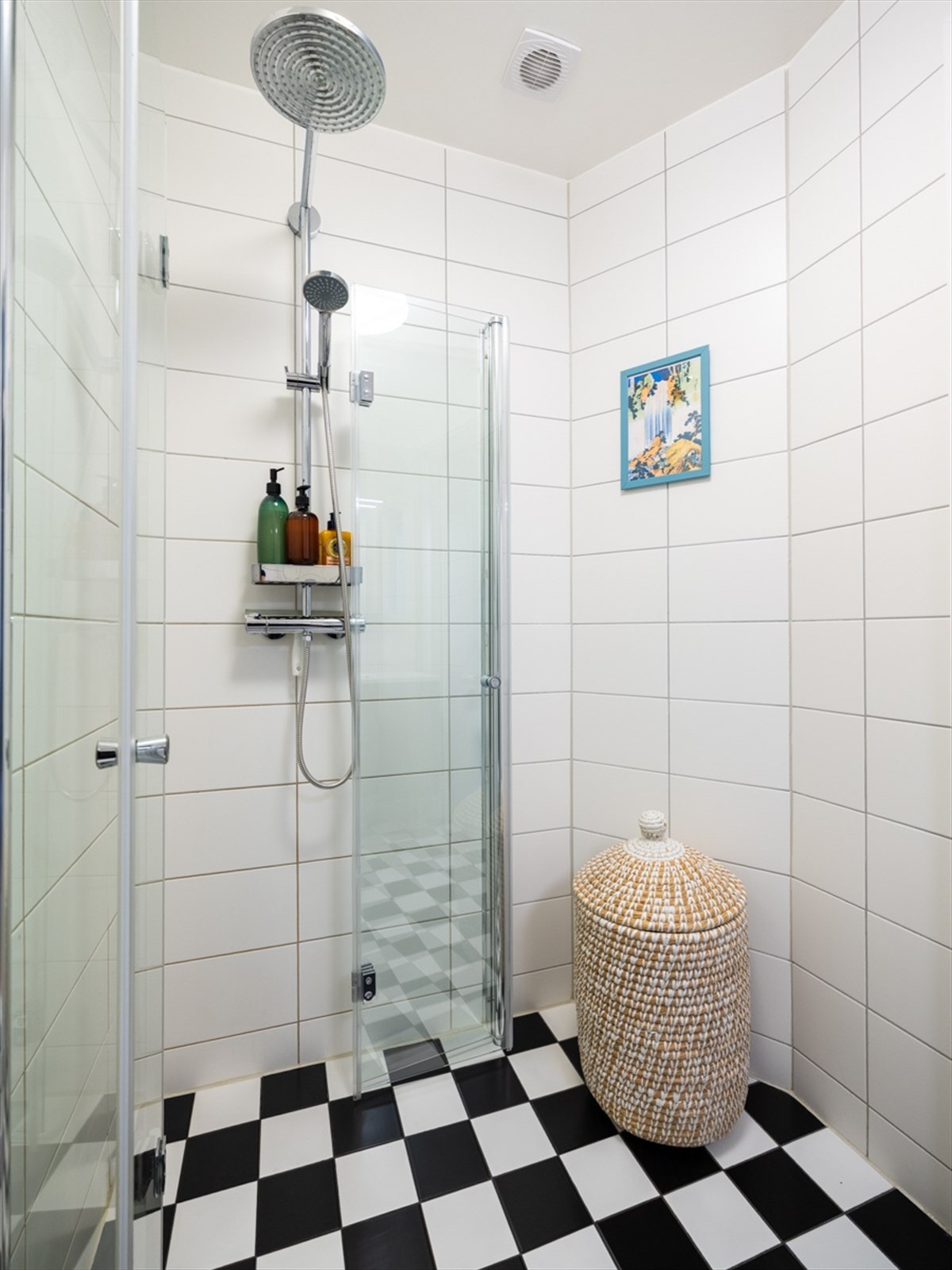 Badet har vegghengt toalett og Kuma servantinnredning med mørke glatte fronter Galleribilde