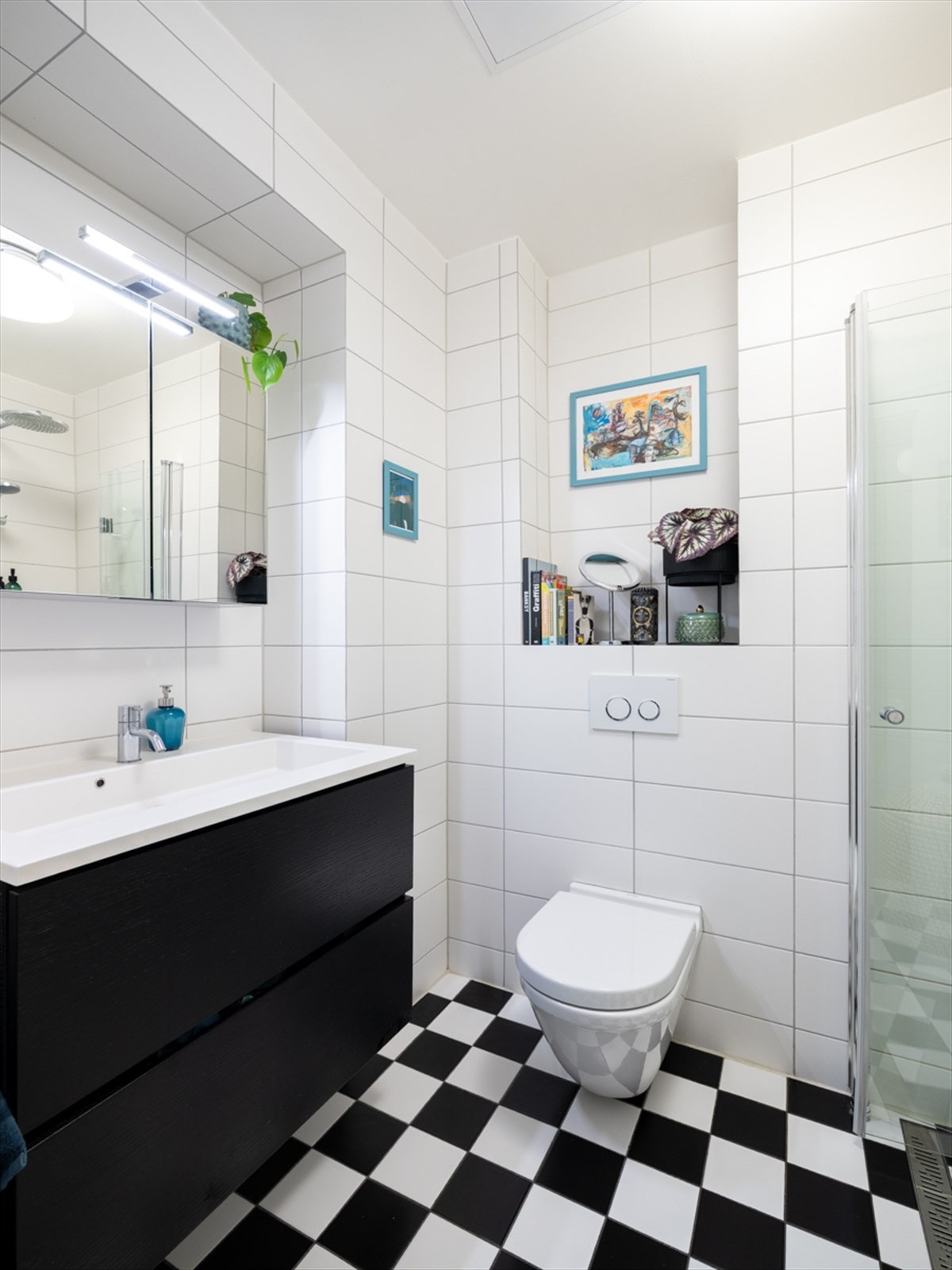 Badet er innredet med hvit heldekkende servant, ett-greps servantarmatur fra Vola og et speilskap med LED-belysning Galleribilde