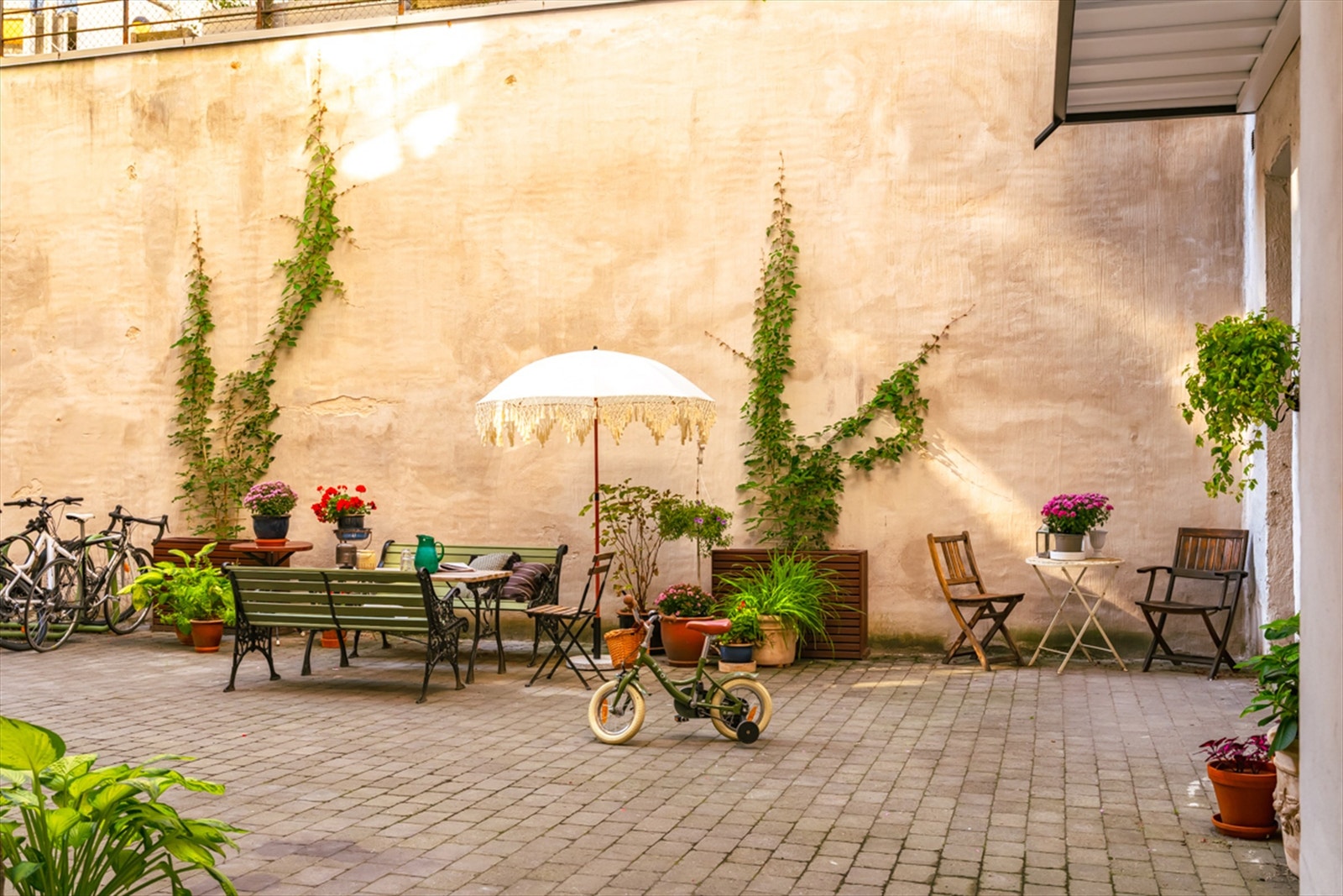 Utenfor kan du trekke deg tilbake i en barnevennlig og koselig bakgård, eller nyte sol og blomster i den pent opparbeidede forhagen Galleribilde