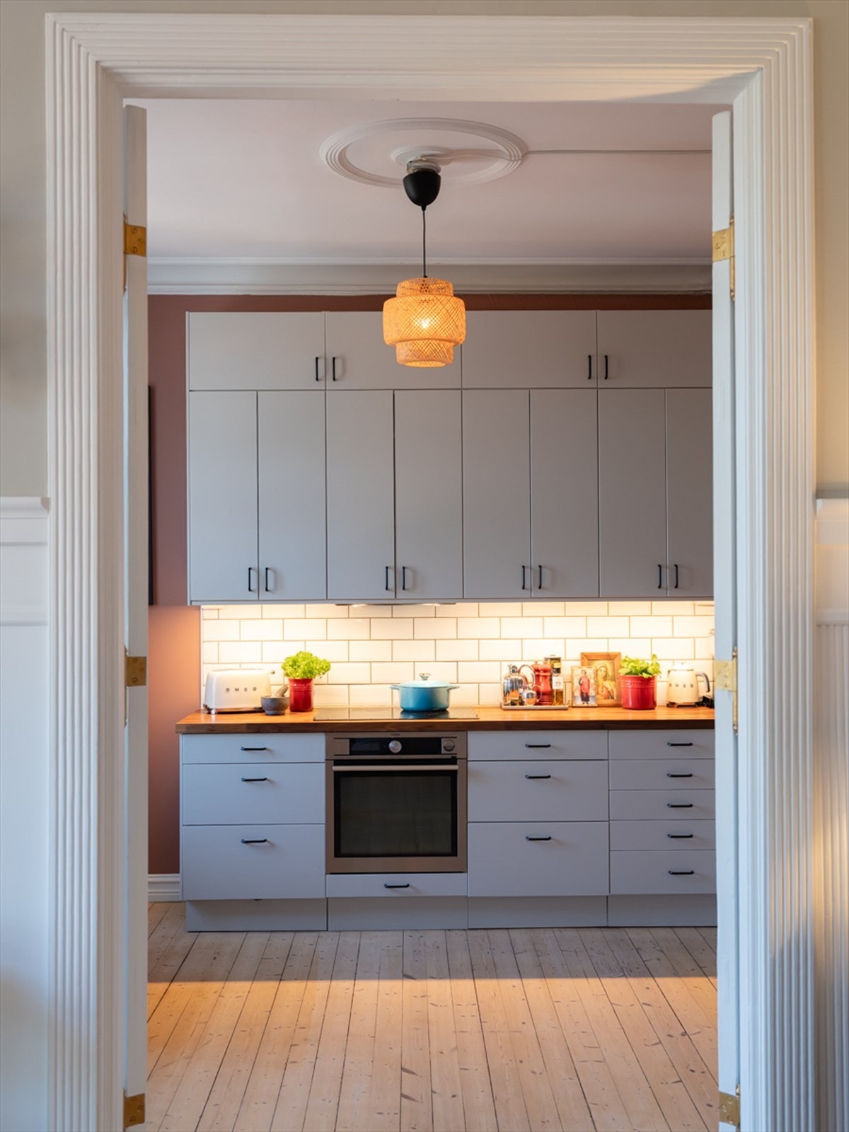 Tidløs kjøkkeninnredning med malte glatte fronter og benkeplater i heltre valnøtt Galleribilde