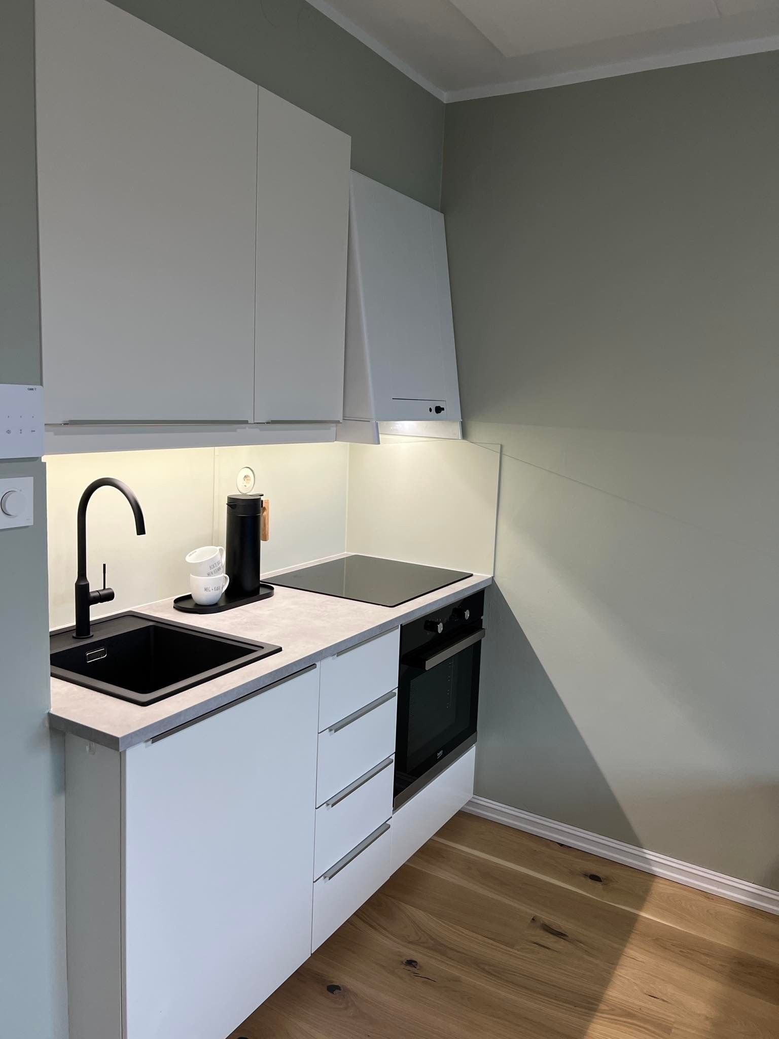 Vegg rundt kjøkkenbenk er malt med våtromsmaling med slitesterk overflate. Galleribilde