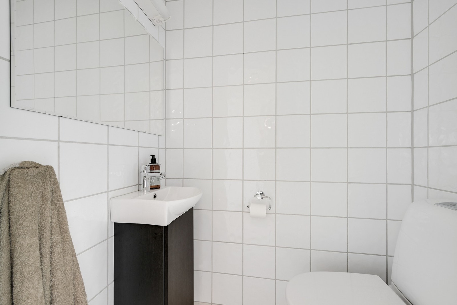 Separat toalettrom i 1. etasje med enkel innredning, bestående av speil, servant med underskap, og klosett. Galleribilde