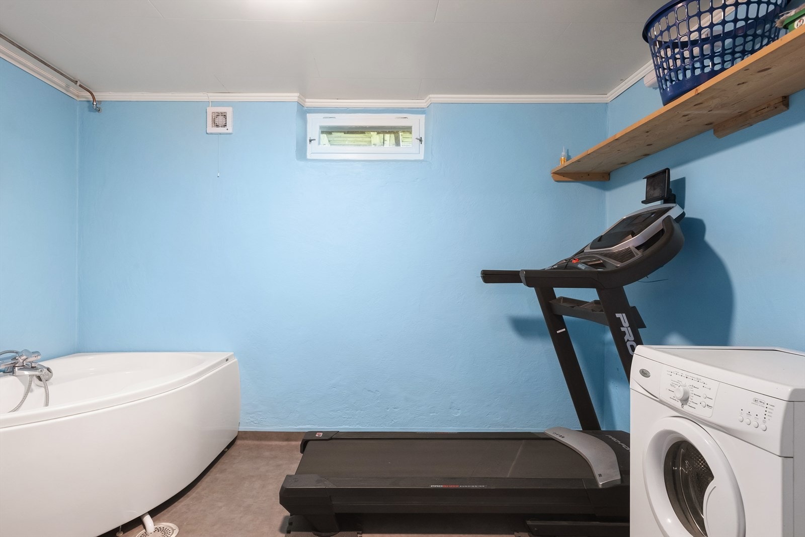 Vaskerom i kjeller med belegg på gulv om malte betongvegger. Opplegg for vaskemaskin og innredet med badekar. Varmekabler i gulv. Galleribilde