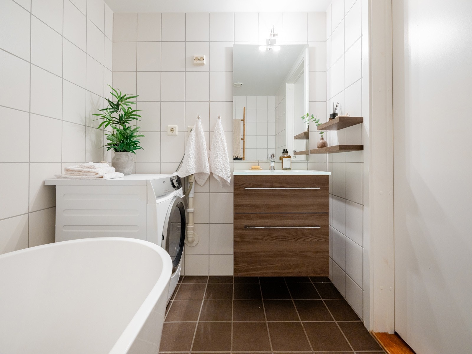 Baderommet har vegghengt servantskap med heldekkende servant, speil, overlys og stikkontakt over servant samt to dekorative hyller. Galleribilde