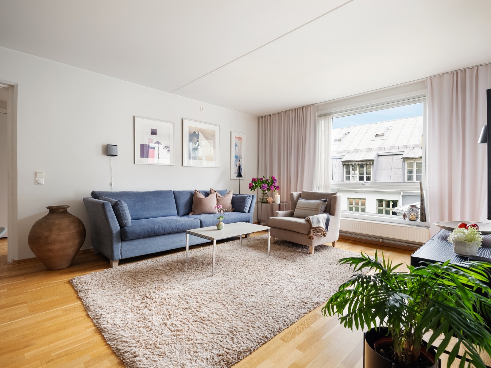 Leiligheten har en lys og romslig stue med naturlige møbleringssoner. Galleribilde