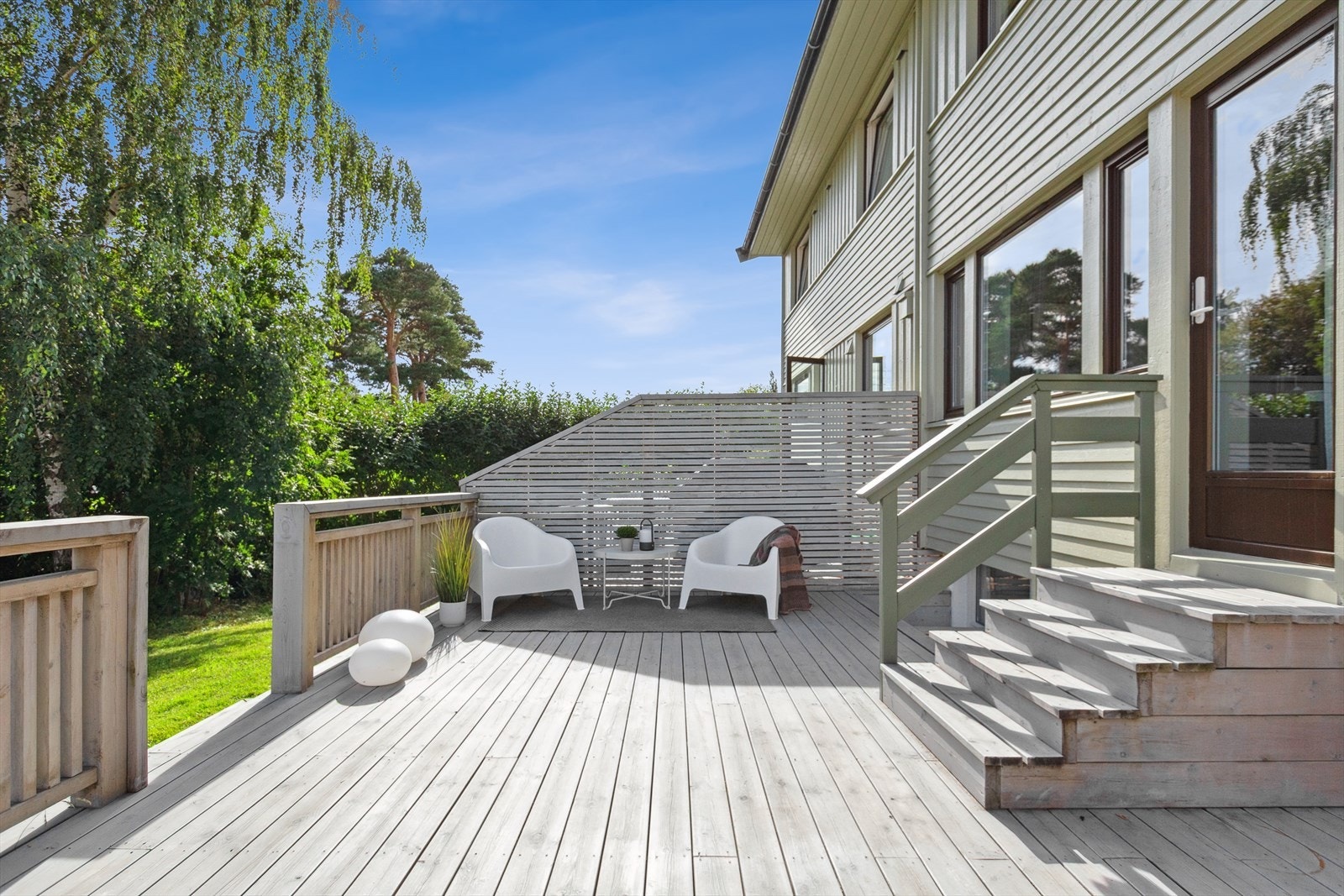 Solrik terrasse med plass til sittegrupper og grill. Nedgang til store grøntareal. Galleribilde
