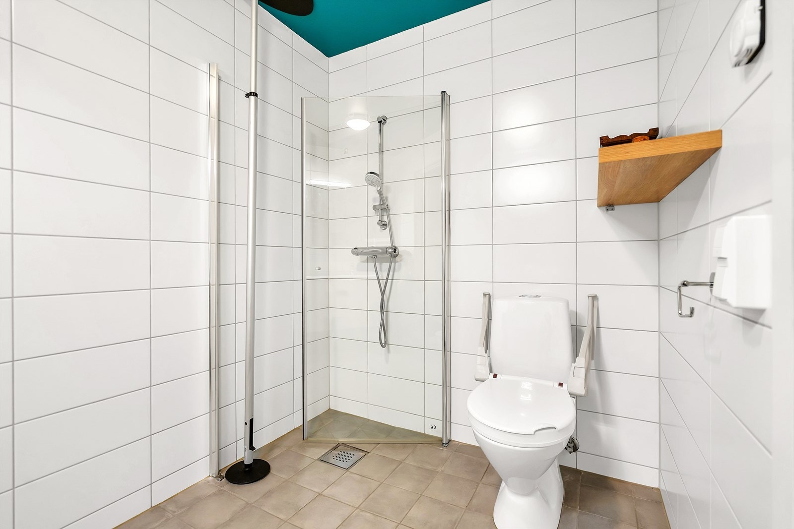 Badet er utstyrt med toalett, dusjhjørne og servant med underskap Galleribilde