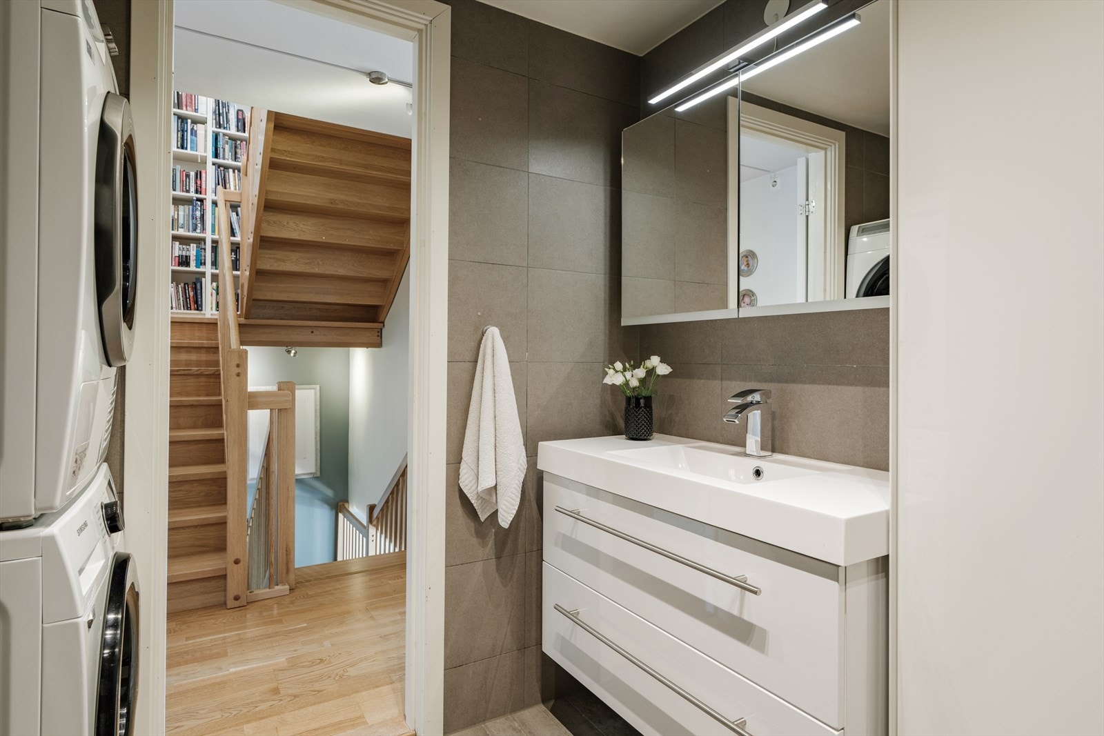 Stilrent flislagt bad med opplegg for vaskemaskin og plass til tørketrommel. Galleribilde