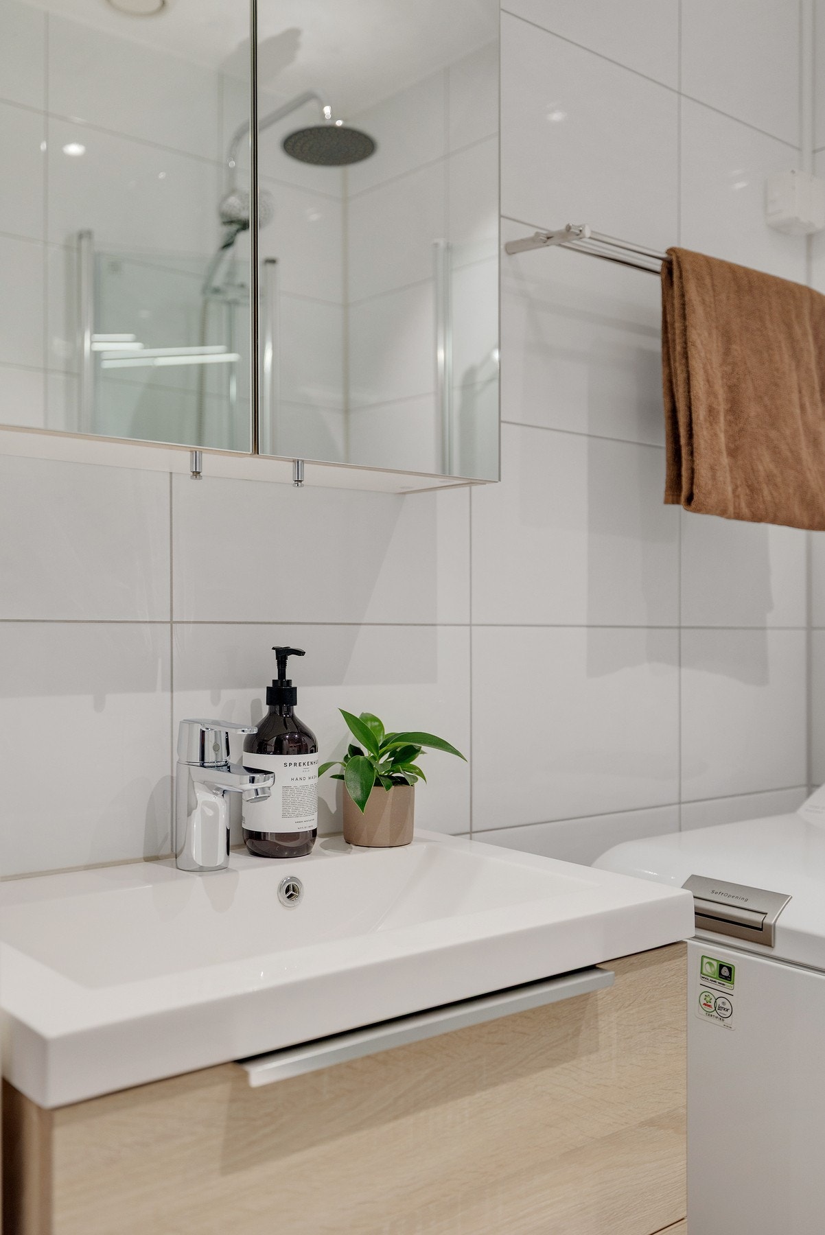 Badet har servant med benkeskap, speilskap med belysning, veggfestet toalett og opplegg for vaskemaskin. Galleribilde