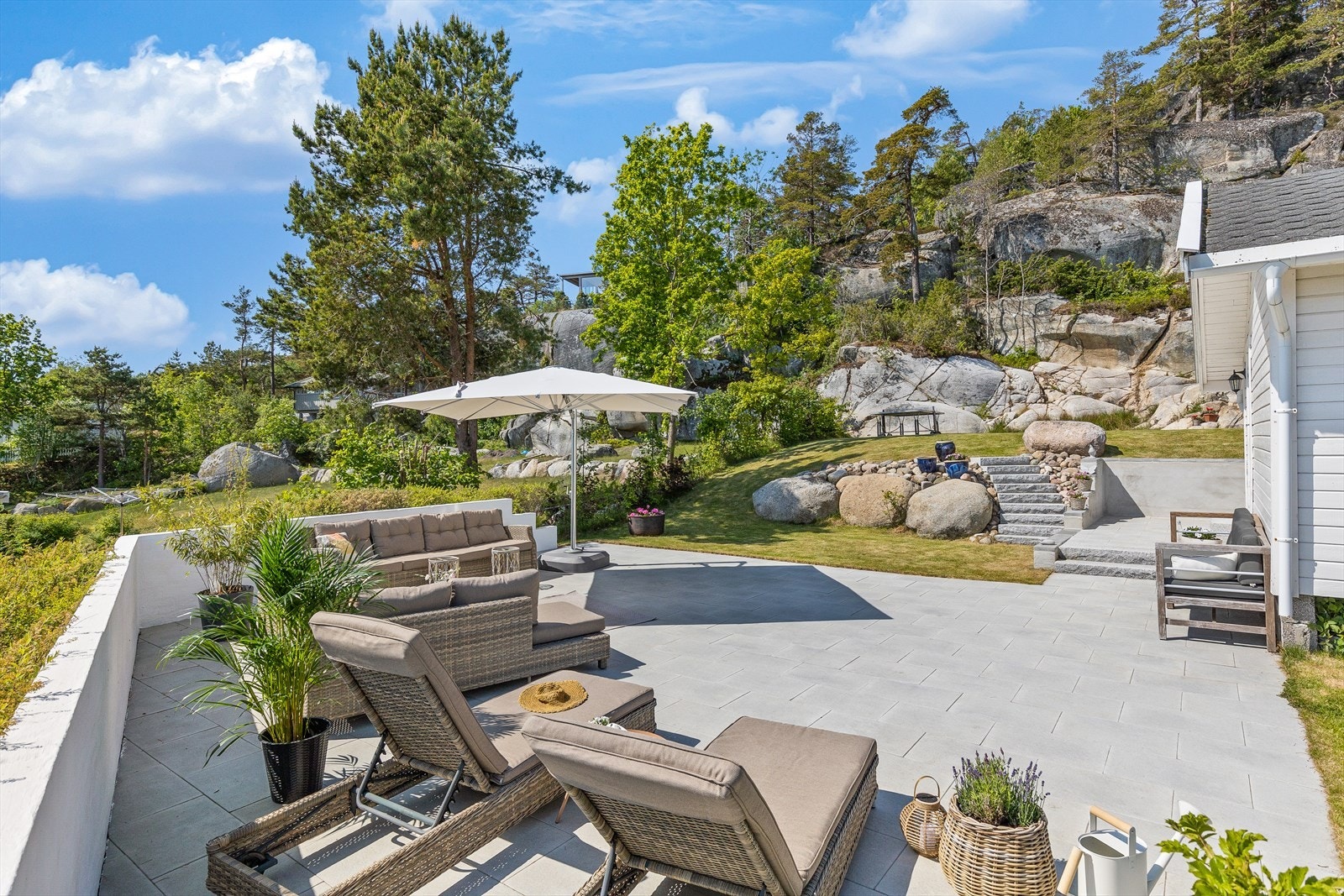 Deler av uteområdet er belagt med heller og har murvegg som gir skjerming for innsyn og vind Galleribilde