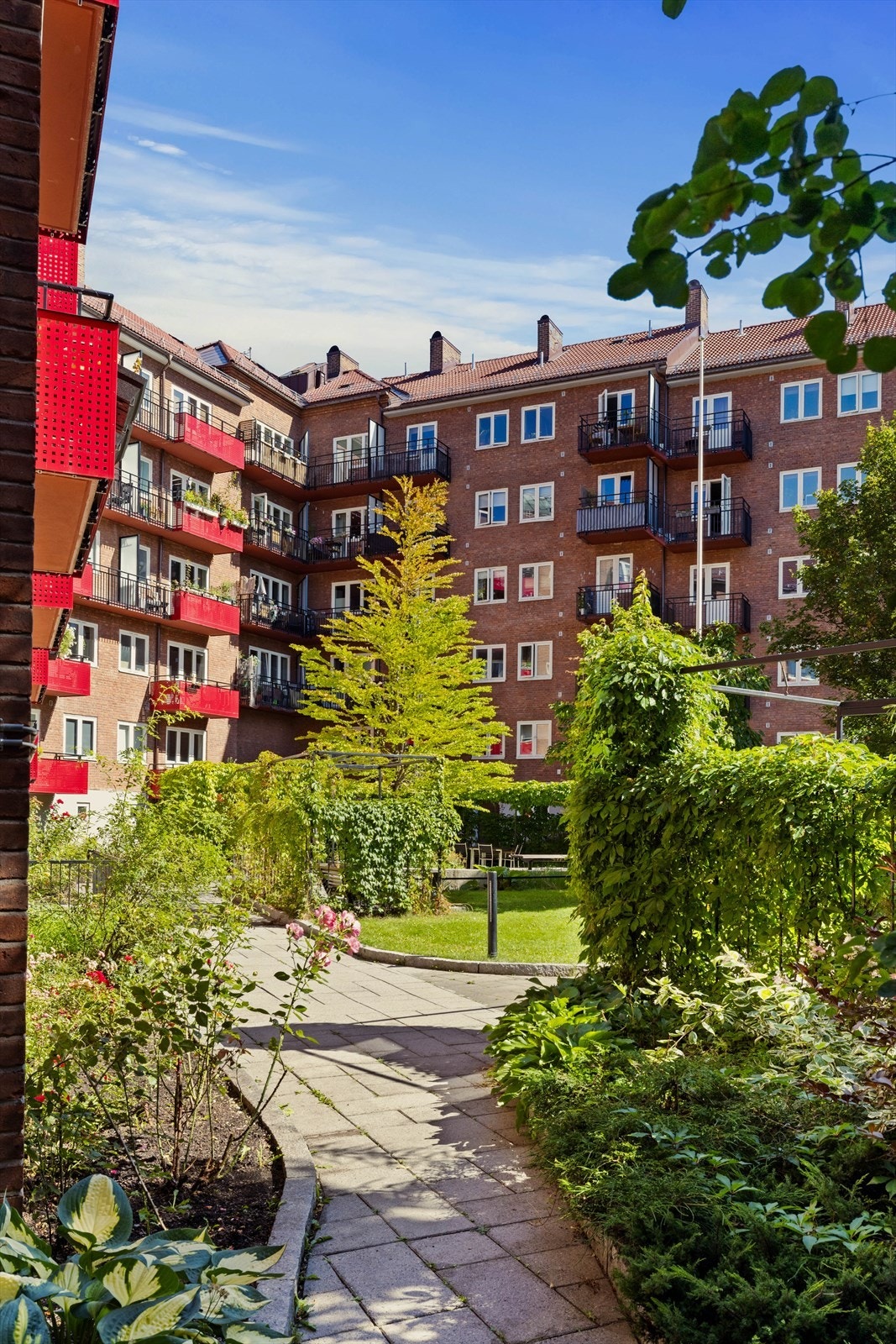 Sjarmerende gangsti leder deg inn i et grønt og rolig gårdsrom. Galleribilde