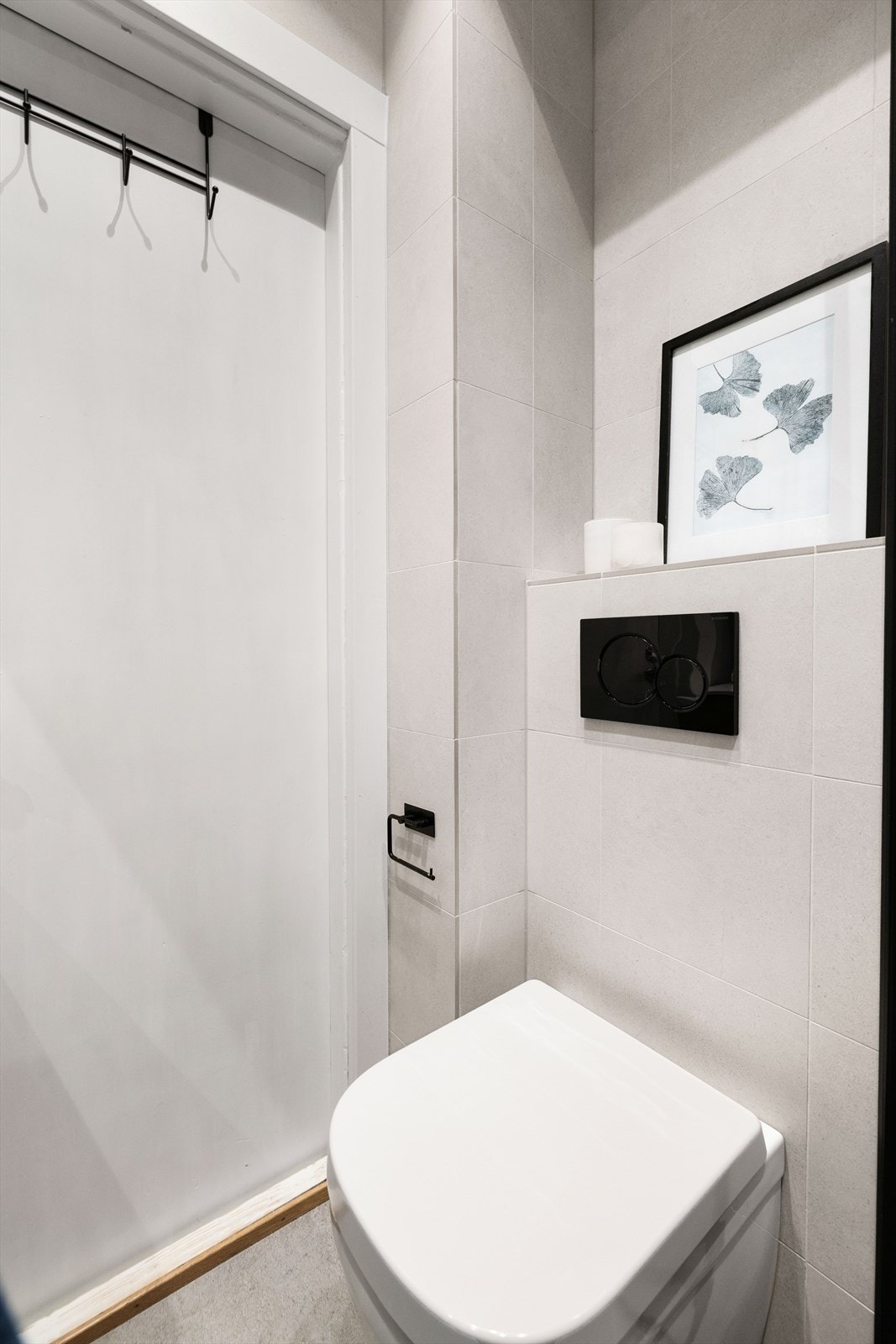 Vegghengt toalett og tidløse fliser gir badet et moderne uttrykk. Galleribilde