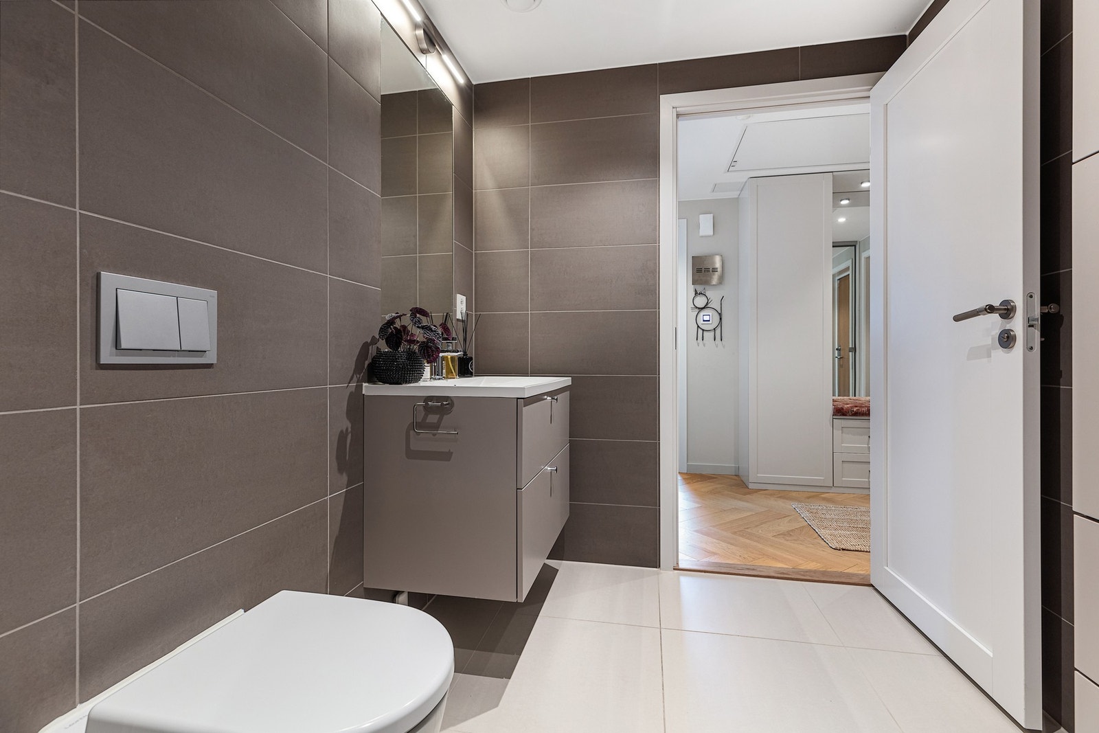 Bad ved entré er smakfullt flislagt, og har elektriske varmekabler i gulv Galleribilde