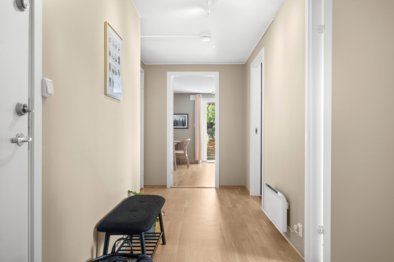 Videre kommer du til en gang med parkettgulv og lysmalte vegger. Galleribilde