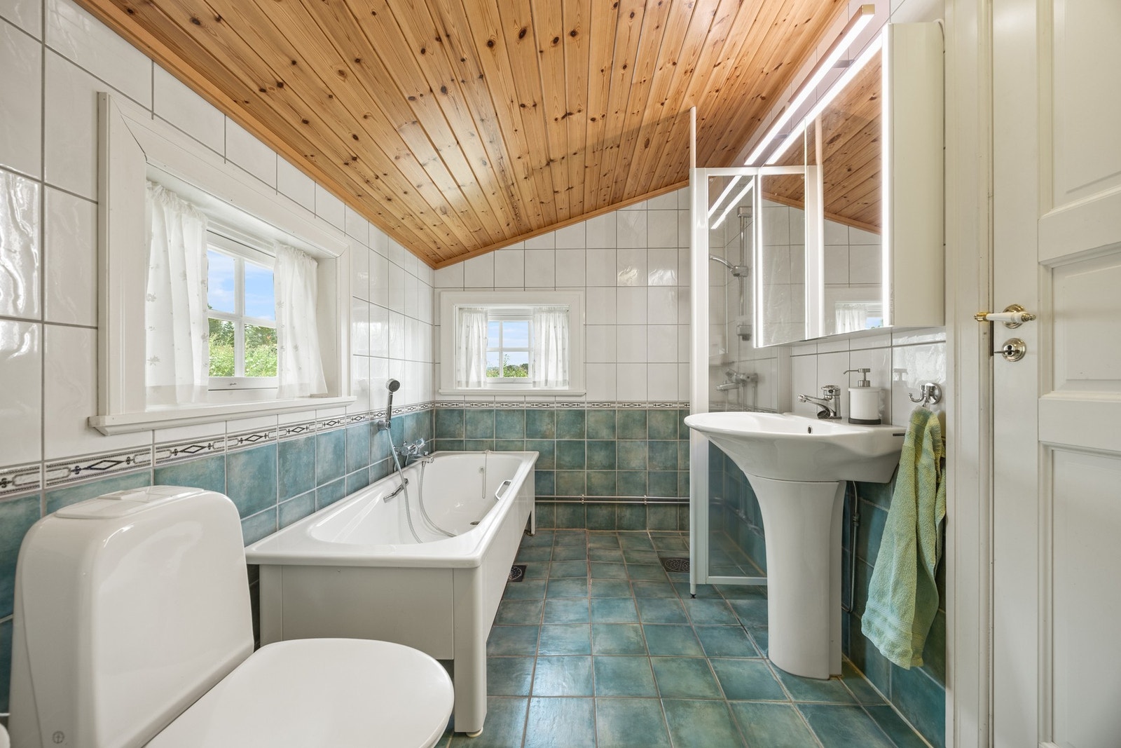 Utstyrt med dusjhjørne, badekar, servantskap og toalett Galleribilde