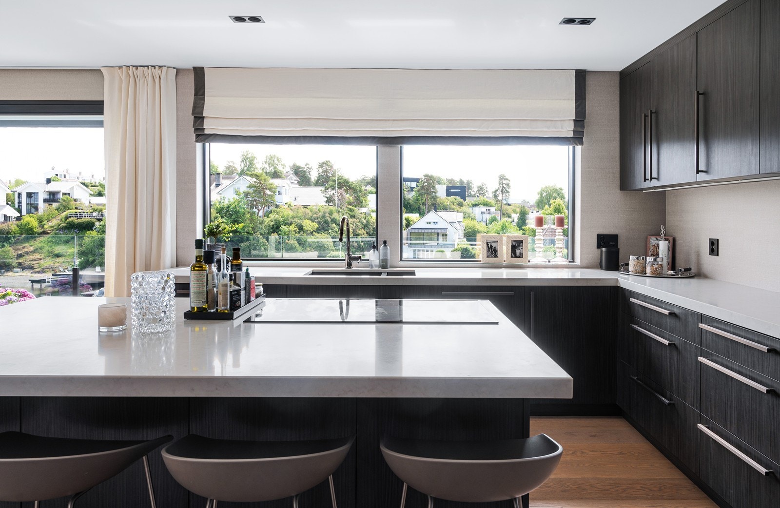 Stor kjøkkenøy i samme utførelse og kvalitet som resten av innredningen, her er det laget til med praktiske sitteplasser under benkeplaten. Galleribilde