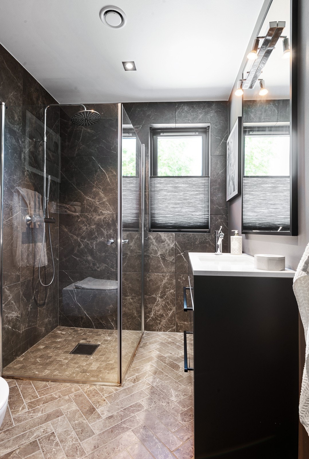 Bad i hovedetasje med elektriske varmekabler i gulvet og downlights i himling. Badet er utstyrt med innredning med nedfelt servant, veggmontert toalett og dusjhjørne med glassdører. Galleribilde