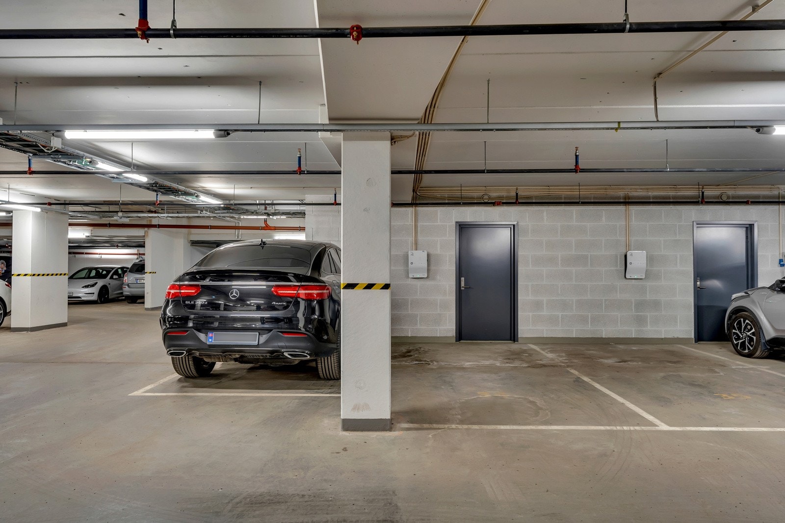 Det følger to parkeringsplasser til leiligheten, begge har elbillader. Plassene ligger ved siden av hverandre. (Plassene på hver sin side av søylen) kjellerbod i nærheten av plassene. Galleribilde