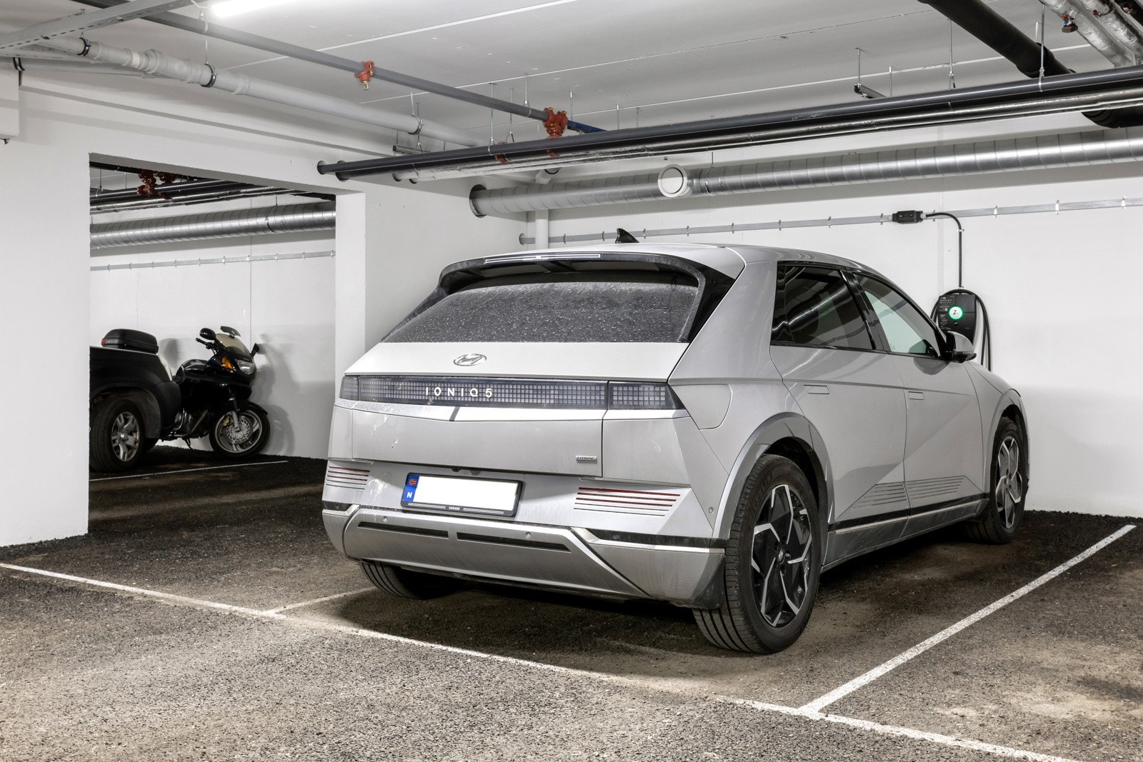 Egen parkeringsplass i kjeller med el-bil lader Galleribilde