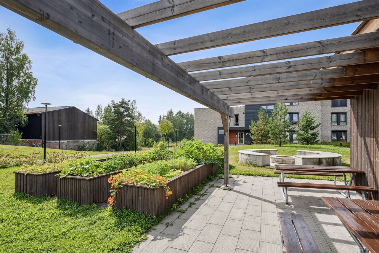 Felles utearealer med overbygd pergola og plantekasser Galleribilde