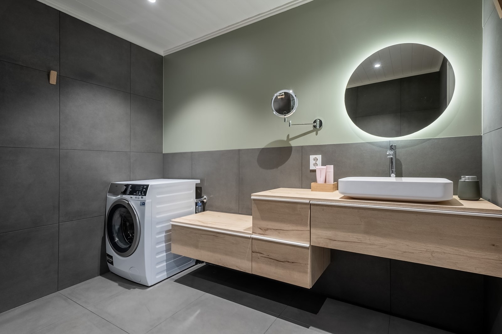 Badet har moderne baderomsinnredning og opplegg for vaskemaskin Galleribilde