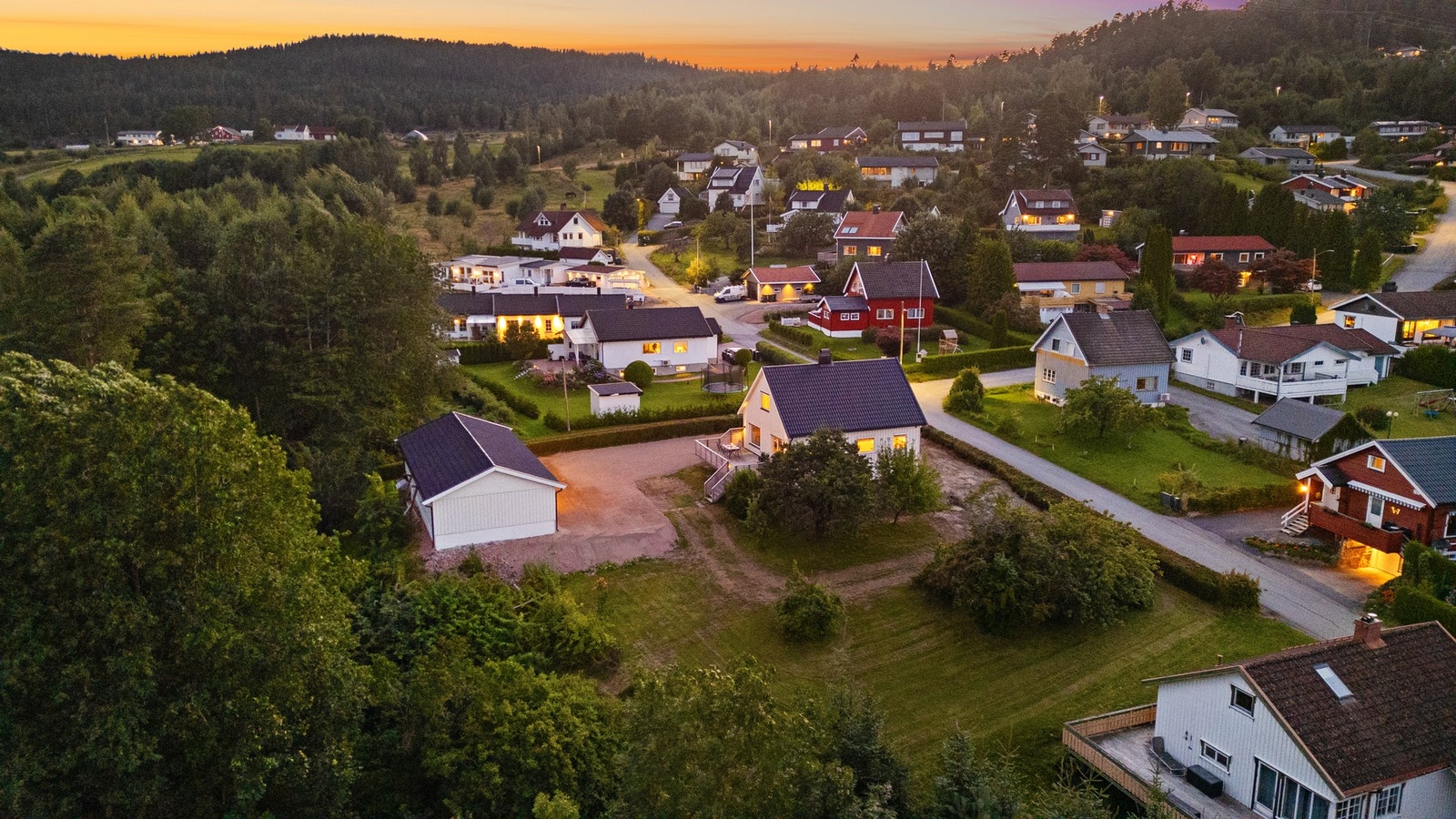 Tomten er opparbeidet med plen og diverse beplantning Galleribilde