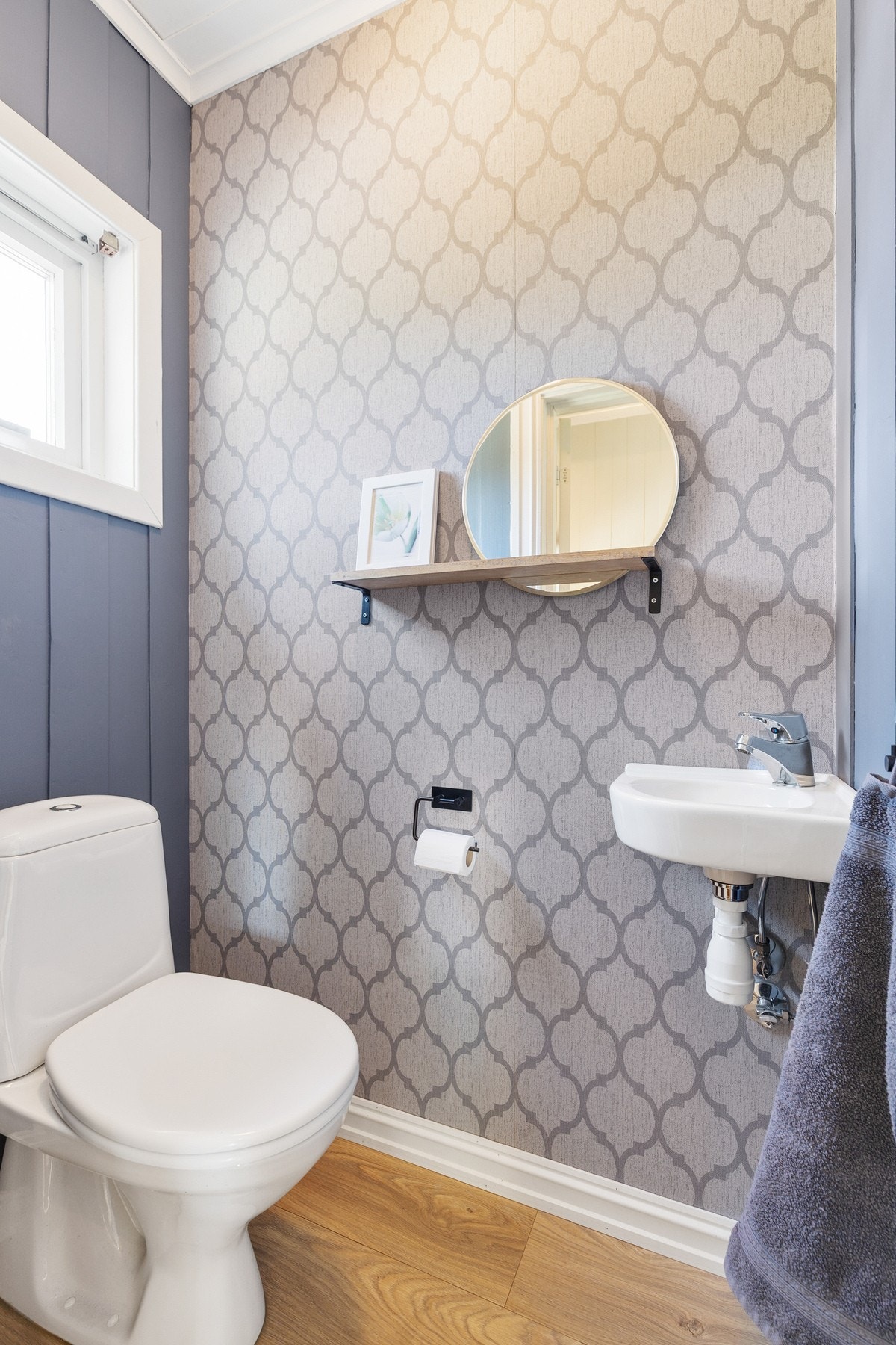 Toalettrom med gulvstående toalett og enkel servant Galleribilde