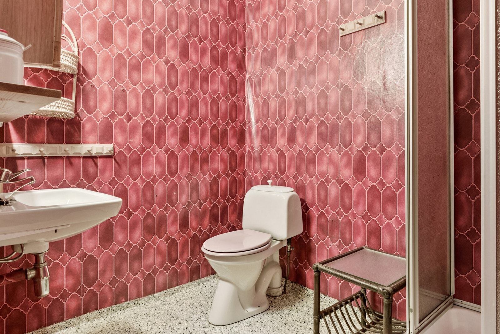 Bad med frittstående toalett, dusjkabinett og vegghengt servant. Galleribilde