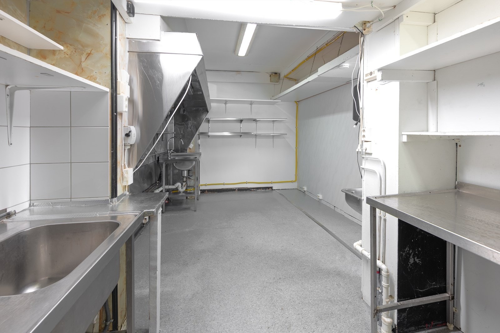 Industri kjøkken med flere utslagskummer og god plass til utstyr for matlaging Galleribilde