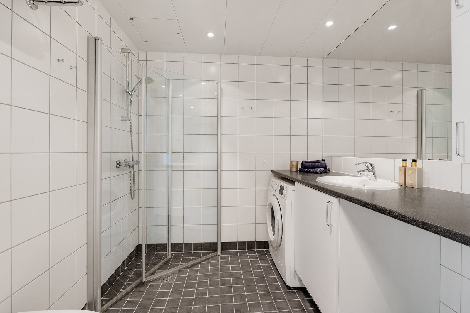 Flislagt bad med gulvvarme og downlights. Galleribilde