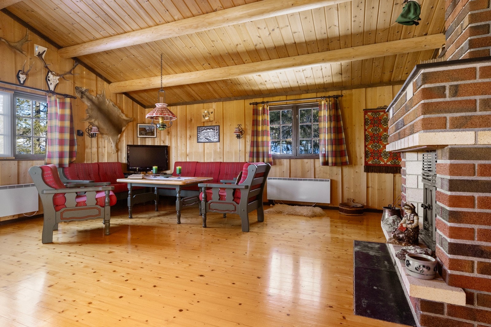 Stuen er et perfekt samlingspunkt, enten du ønsker å slappe av foran den koselige peisen eller nyte varme fra vedovnen på kalde vinterdager Galleribilde