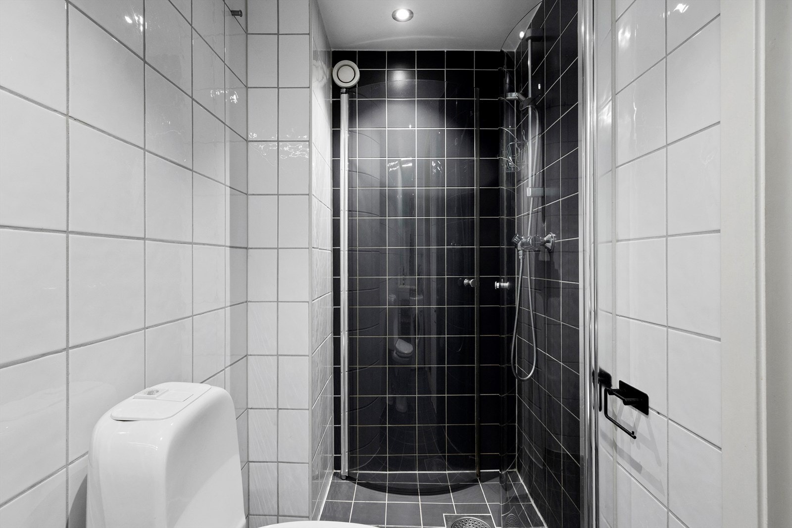 Ellers har badet dusjhjørne med innfellbare dusjvegger og gulvmontert toalett. Galleribilde