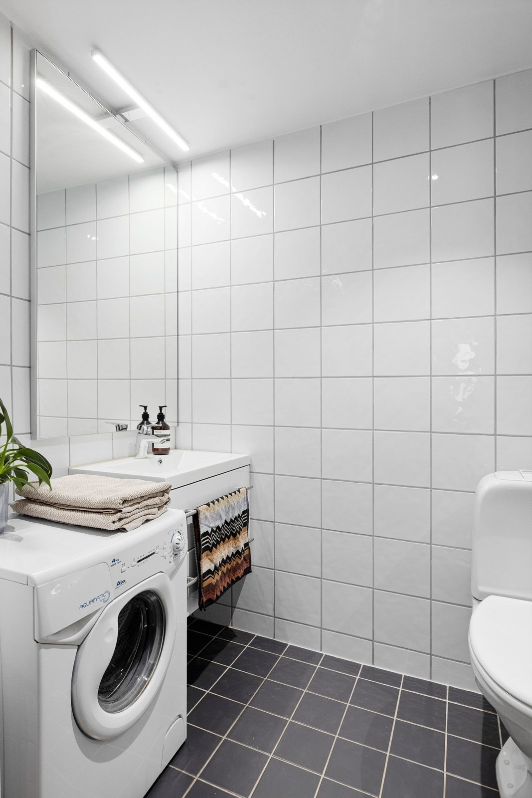 Baderommet har servantinnredning med speil og lys, samt opplegg for vaskemaskin. Galleribilde