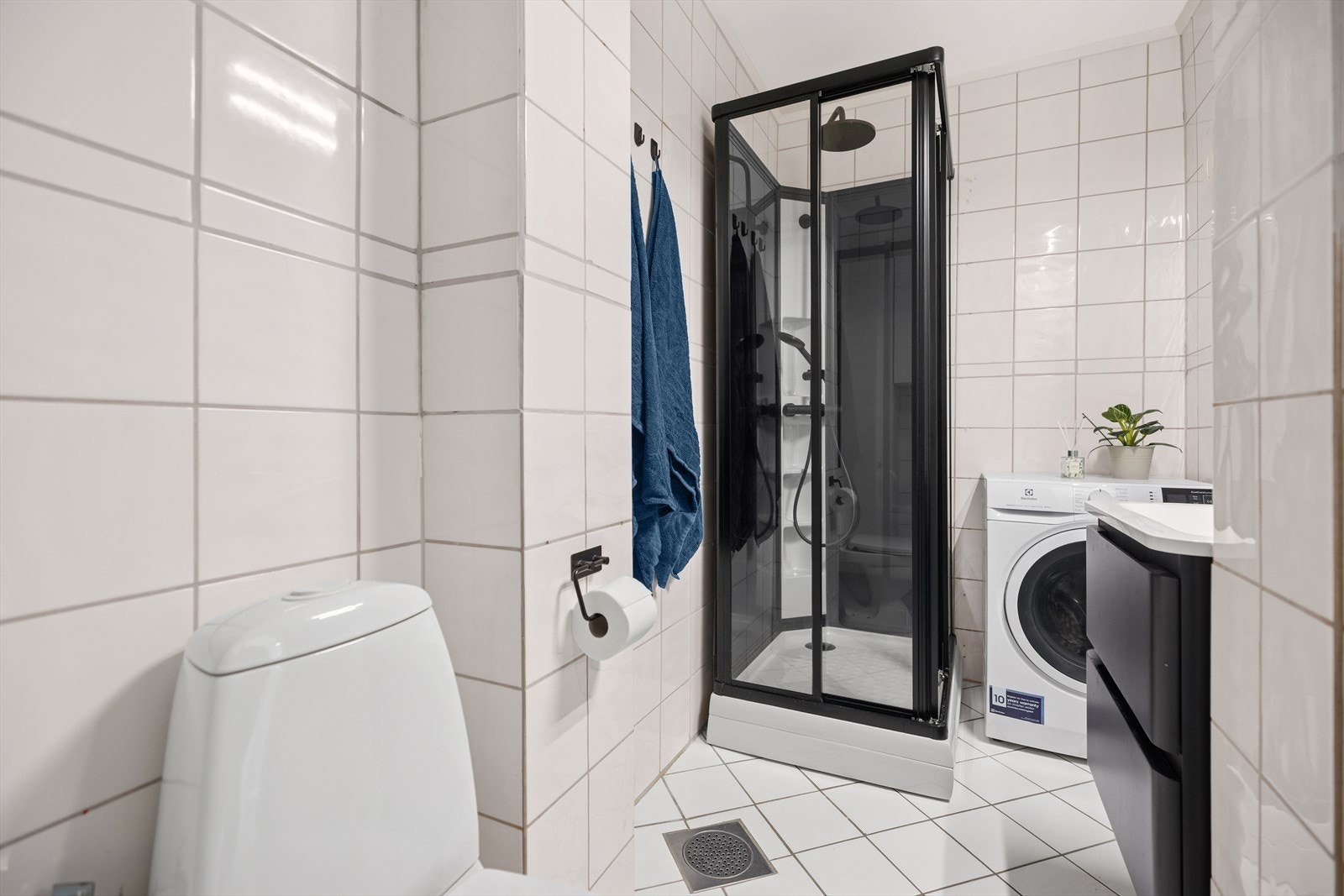 Rommet er utstyrt med toalett, dusjkabinett, baderomsinnredning og opplegg til vaskemaskin. Galleribilde