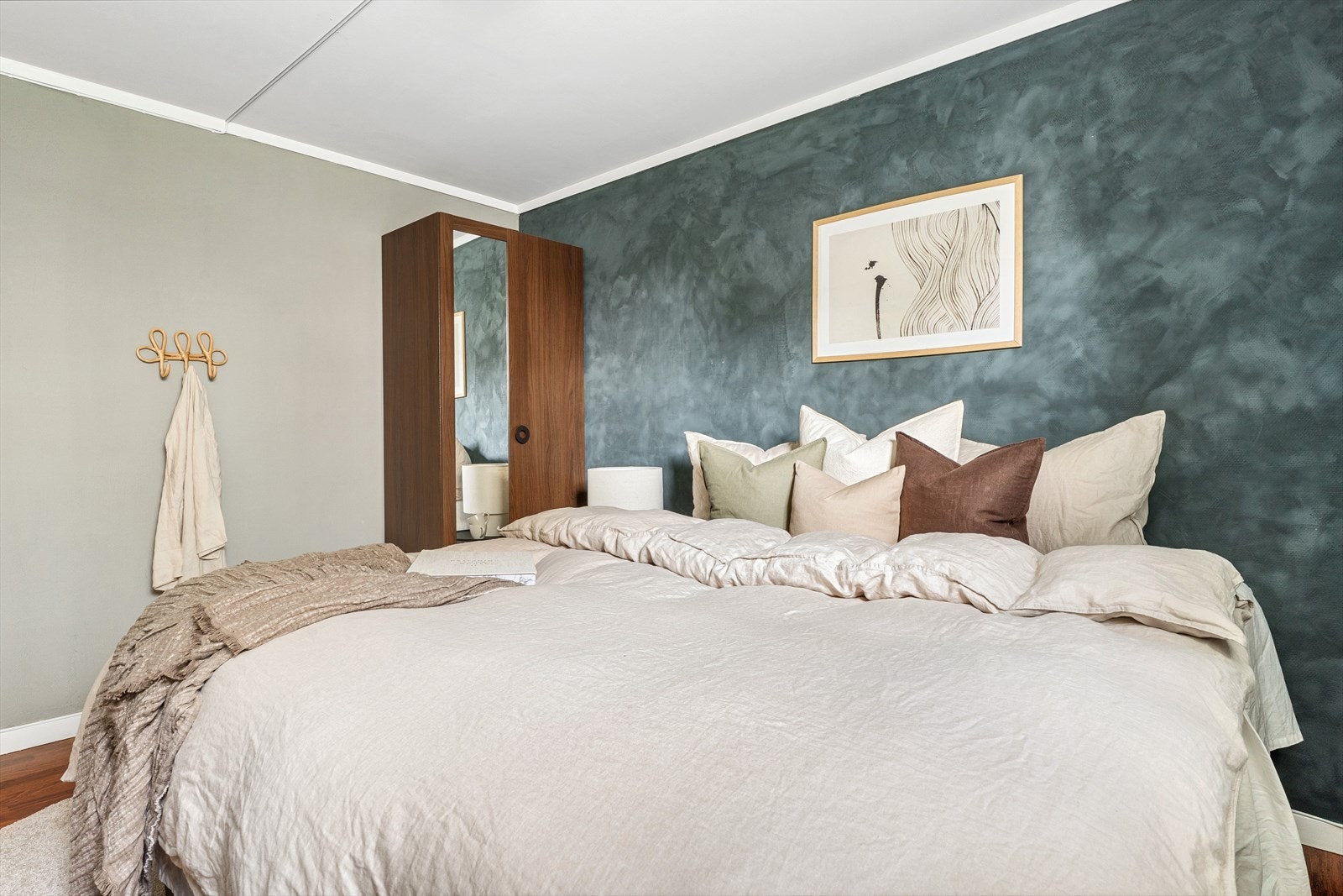 Rommet har plass til en stor dobbeltseng, tilhørende nattbord og garderobeløsning Galleribilde