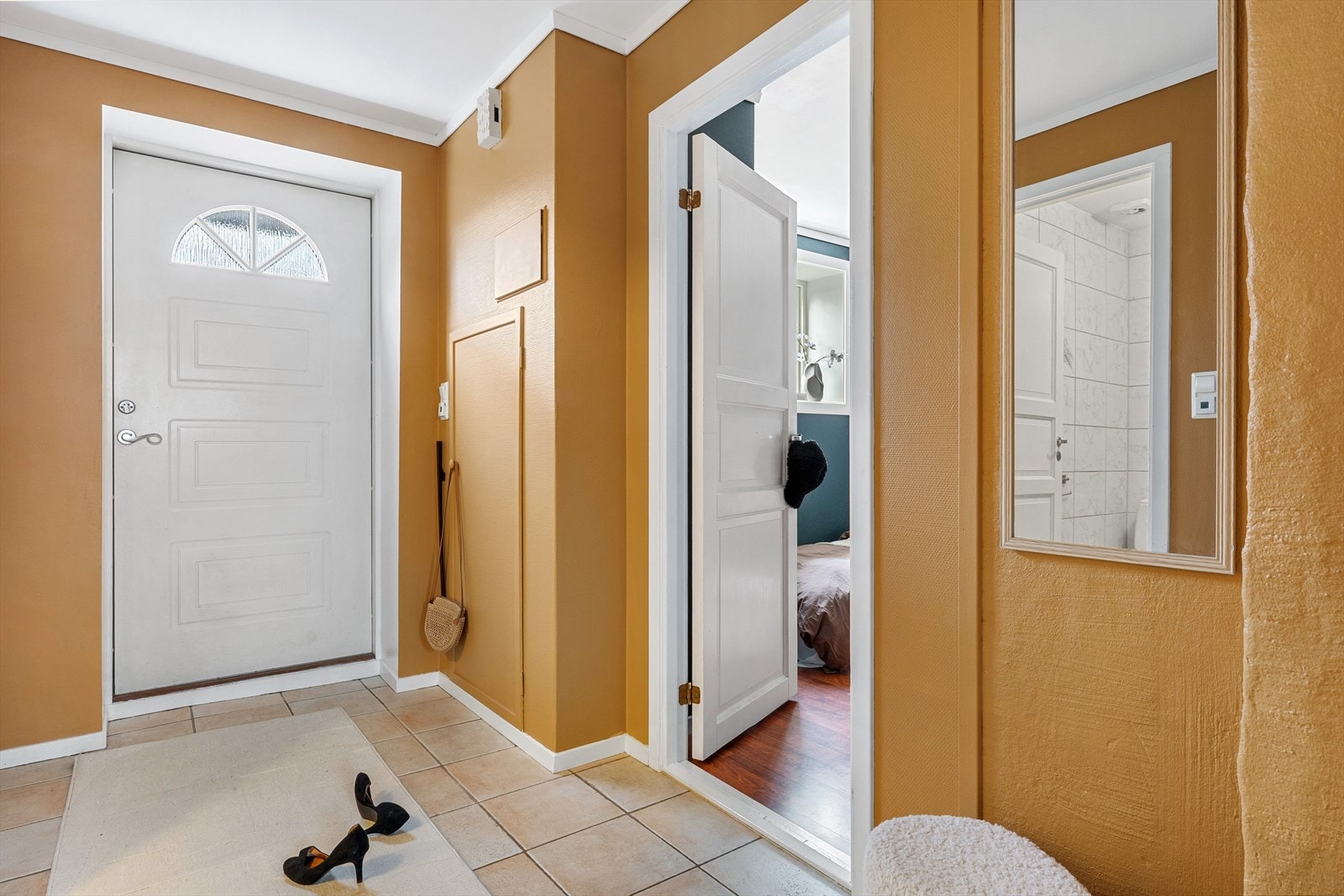 Man blir ønsket velkommen inn i en praktisk entre med flislagt gulv og god plass til å henge fra seg yttertøy Galleribilde