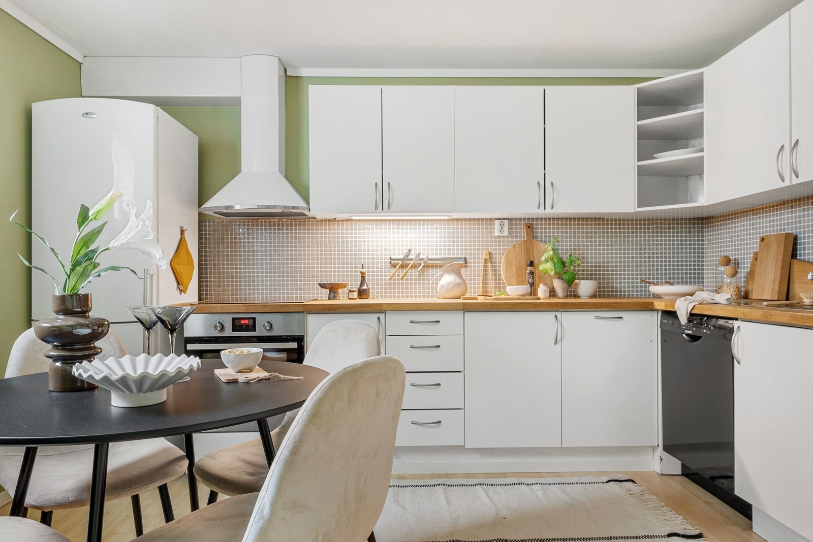 Kjøkkenet har innredning med glatte fronter og laminert benkeplate Galleribilde