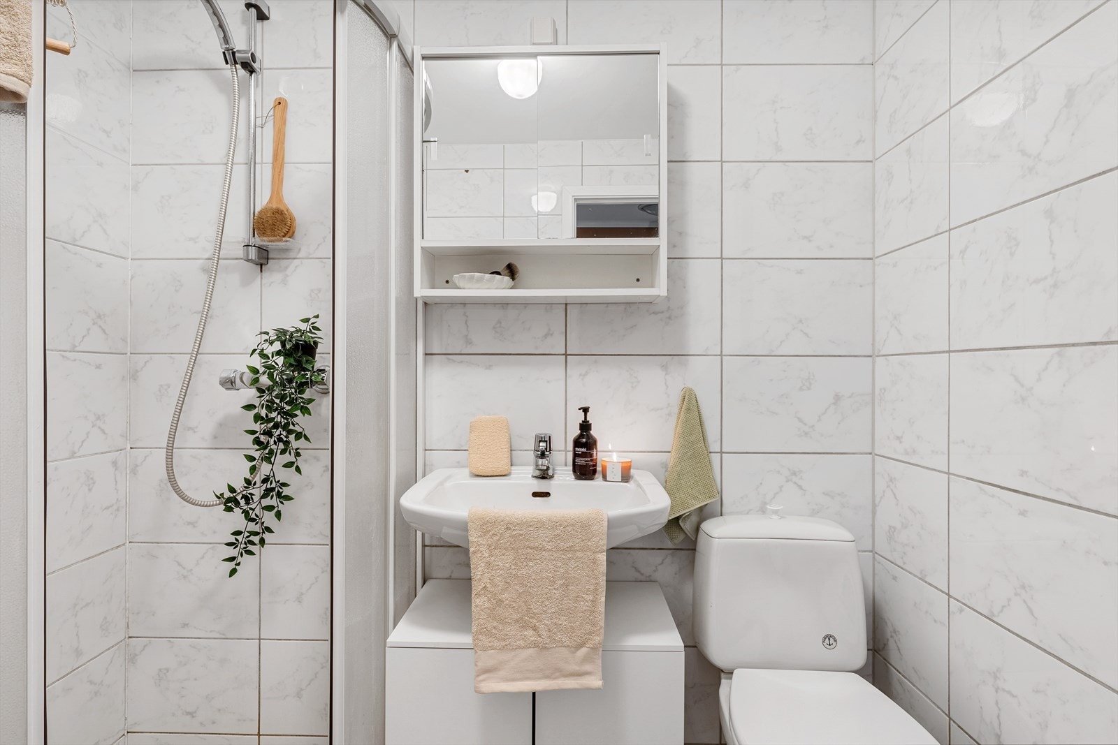 Badet har innredning med nedfelt servant, toalett, dusjhjørne og opplegg for vaskemaskin Galleribilde