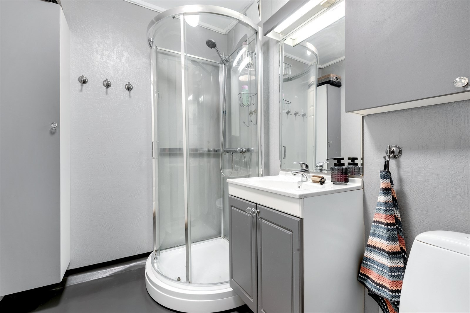 Praktisk bad i første etasje med dusjkabinett og servantinnredning. Galleribilde