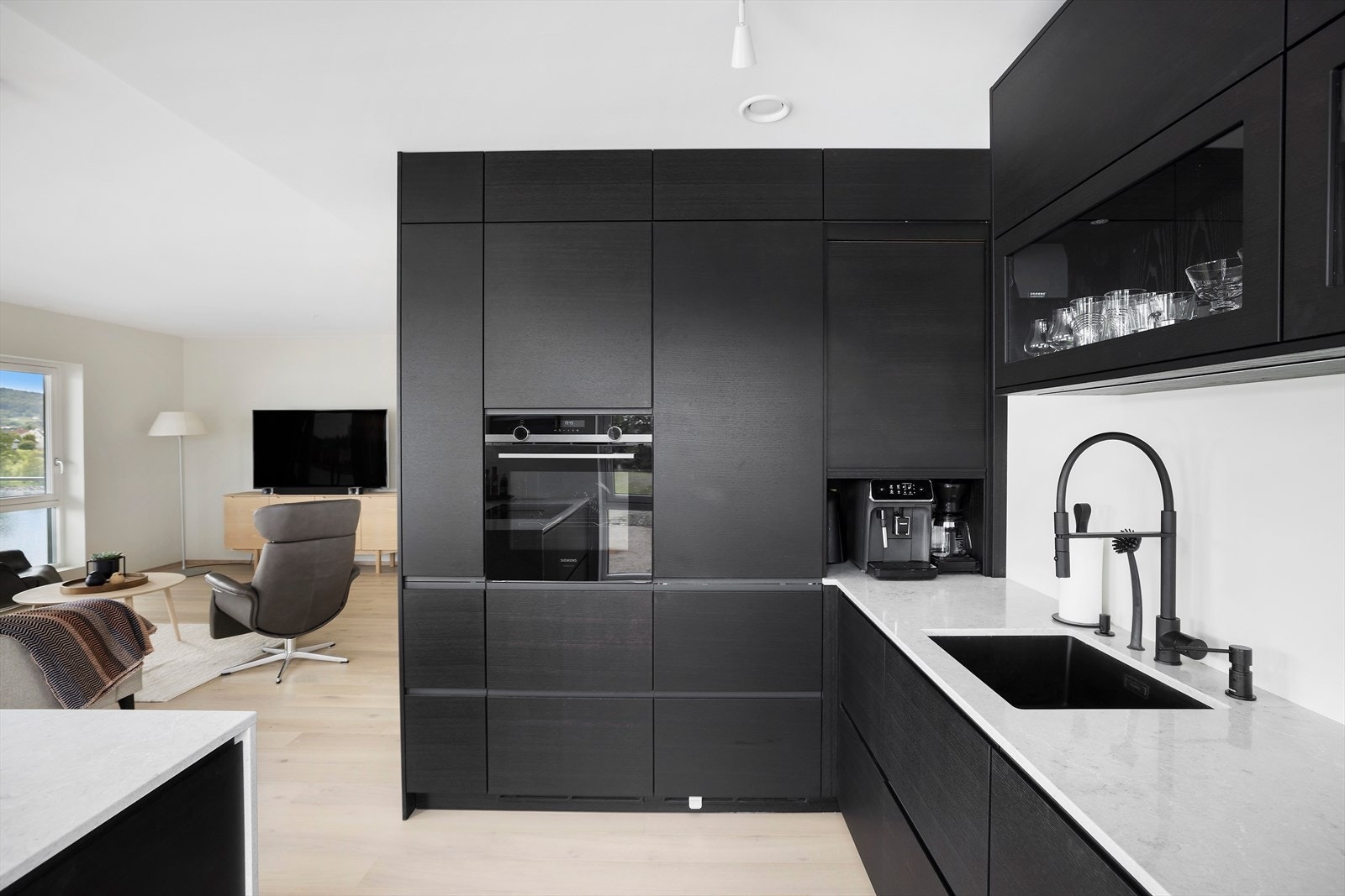 Kjøkkenet tilbyr gode arbeidsflater, rikelig med skapplass og en praktisk kjøkkenøy med waterfall benkeplate Galleribilde