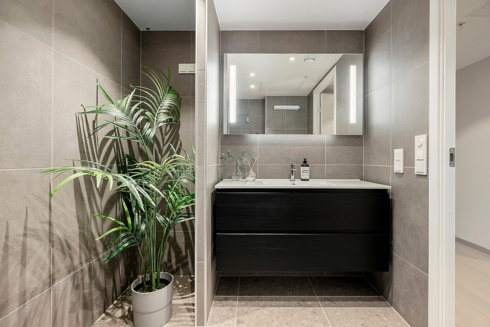 Baderommet er utført i stilen "Nordisk Eleganse" - Moderne innredning med vegghengt speil med integrert lys, samt servant med skuffer Galleribilde