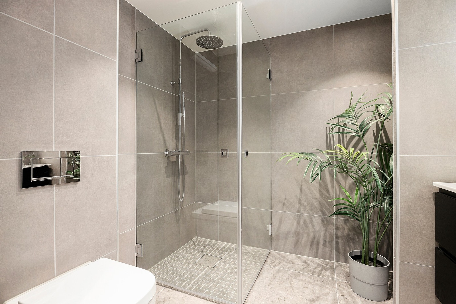 Baderommet er lyst og romslig og har dusjsone med glassdører. Det er opplegg for vaskemaskin og tørketrommel Galleribilde