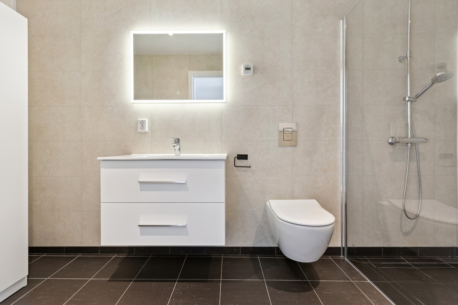 Her finner du heldekkende servant, vegghengt toalett, dusjhjørne med glassvegg og opplegg for vaskemaskin, samt flislagt gulv med vannbåren varme Galleribilde