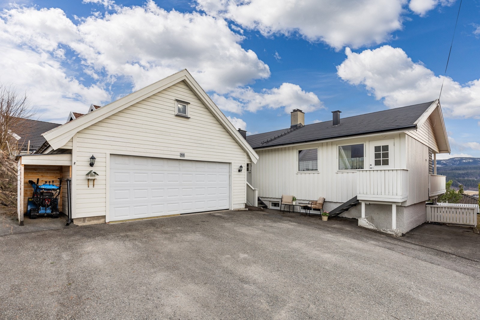 Det er parkering i en frittstående dobbelgarasje på ca. 45 kvm, med lagringsloft, belysning på fasaden og elektrisk portåpner. Galleribilde